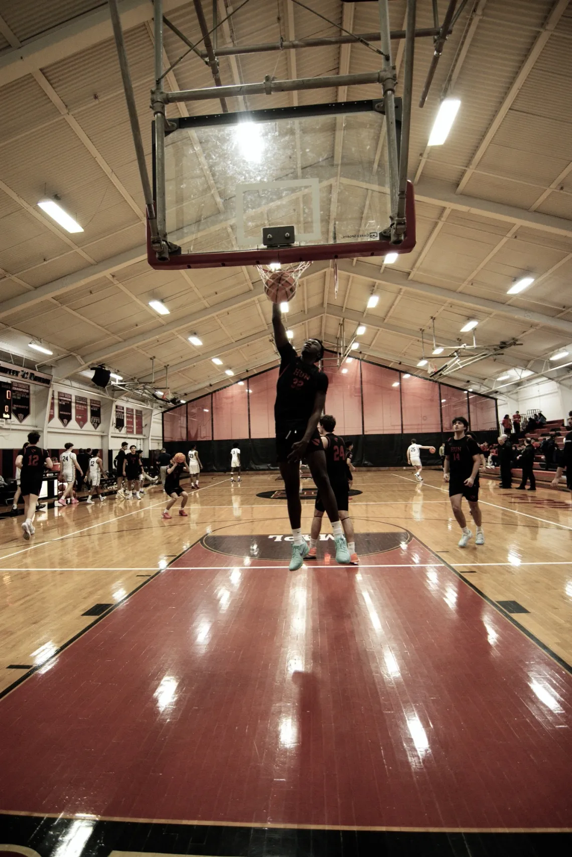 Before a high school basketball game in Princeton, NJ, The Hun School's forward Ben Ayugi (32) reaches for the basket.