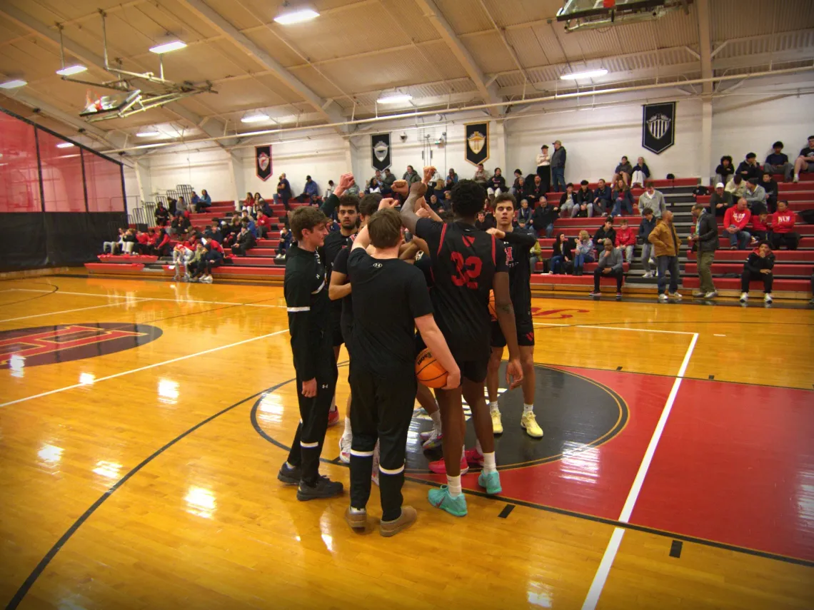 Before a high school basketball game in Princeton, NJ, the Hun School of Princeton's varsity boys basketball team cheer.