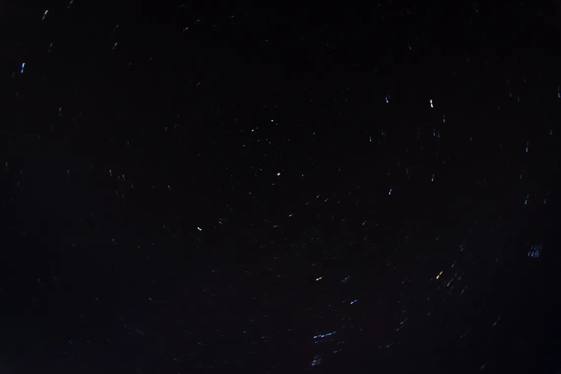 Streaks of stars spin around a central point in the night sky.