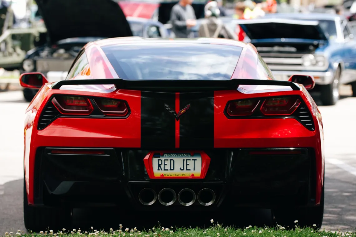 A red sports car with a Pennsylvania license plate reading "RED JET".