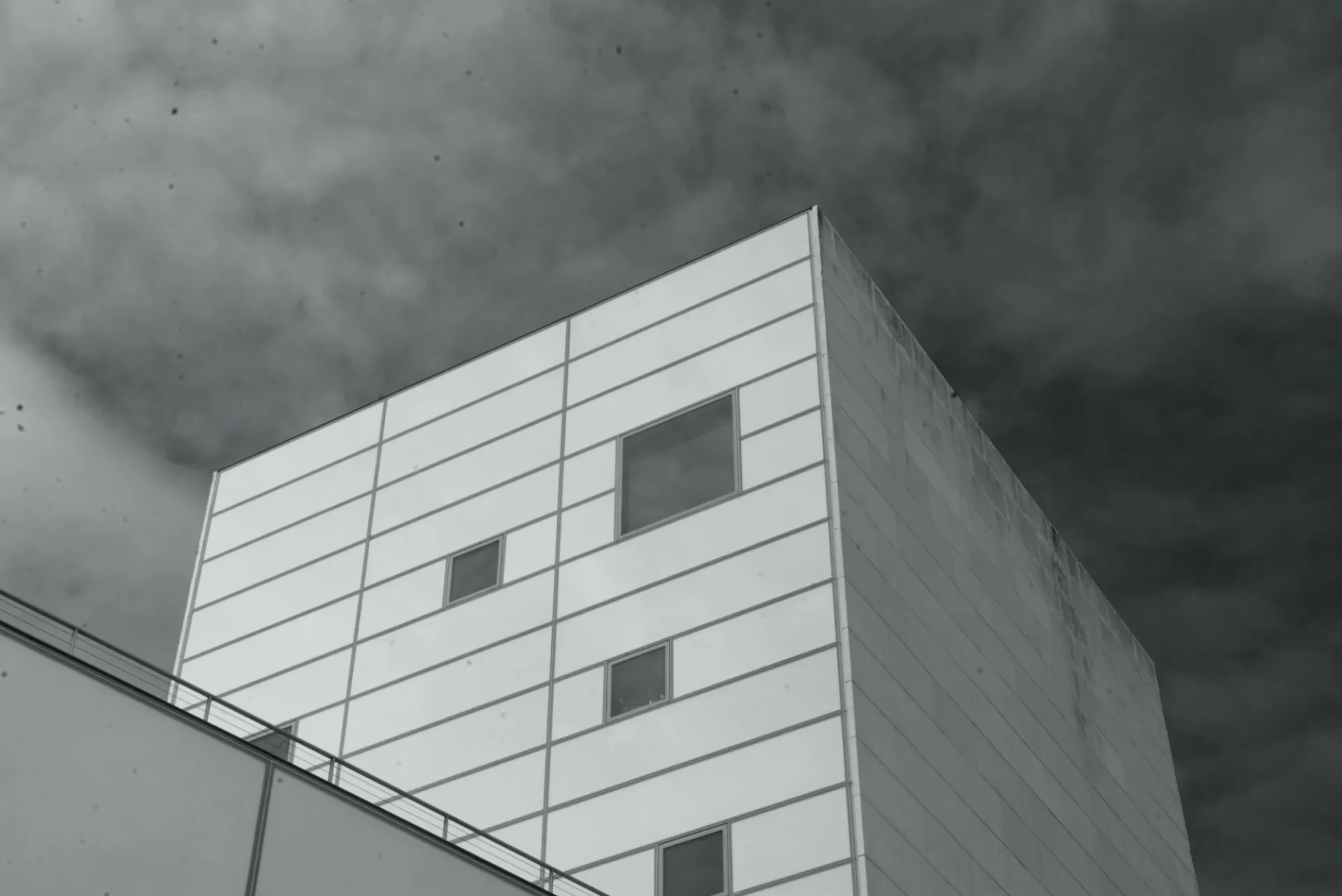 A square building faces the sky, with dots of grime (top-left) stuck to the camera sensor and lens.
