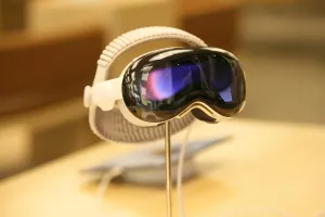 Mounted on a metal pole, the Apple Vision Pro headset is displayed in a shopping mall.
