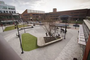 Looking out at a public square from a ledge of the Lancaster Public Library. Green grass is cleanly separated by gray stone bricks.