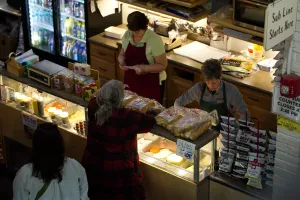 At one boo, a customer chats with two bakers with aprons.