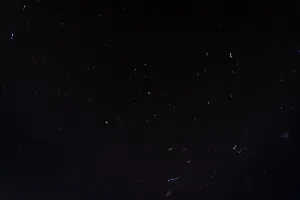 Streaks of stars spin around a central point in the night sky.